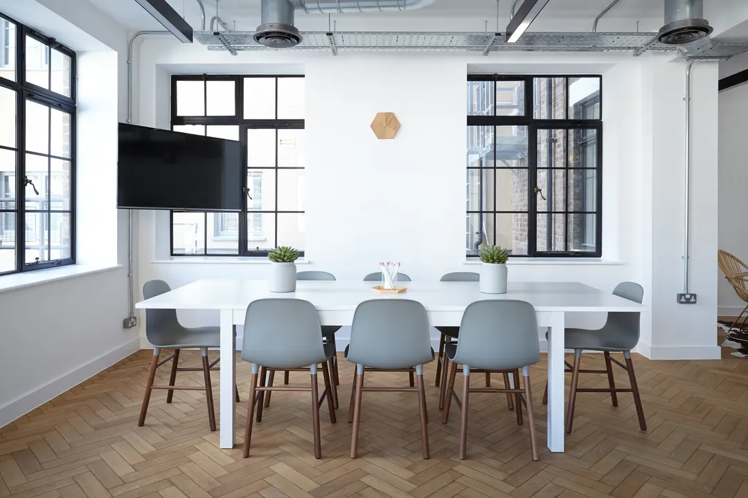Meeting table with grey chairs in a white loft